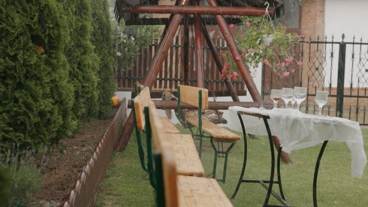 Benches And Tables With Wine Glasses Outdoor Setting On A Rainy Day. Sideways Shot