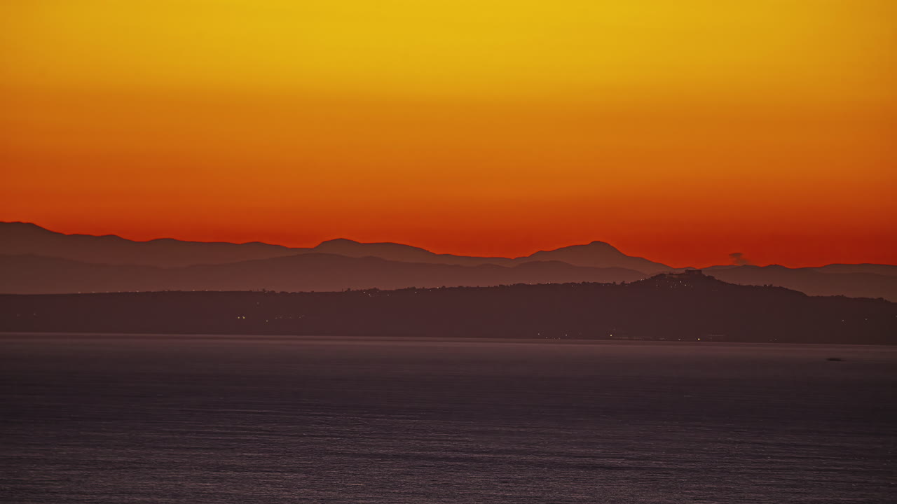 paisaje montañoso con luces de la ciudad y sol brillante