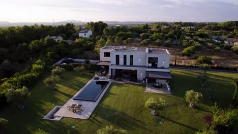 aerial revealing shot of a modern minimal mansion with a private pool in uzes