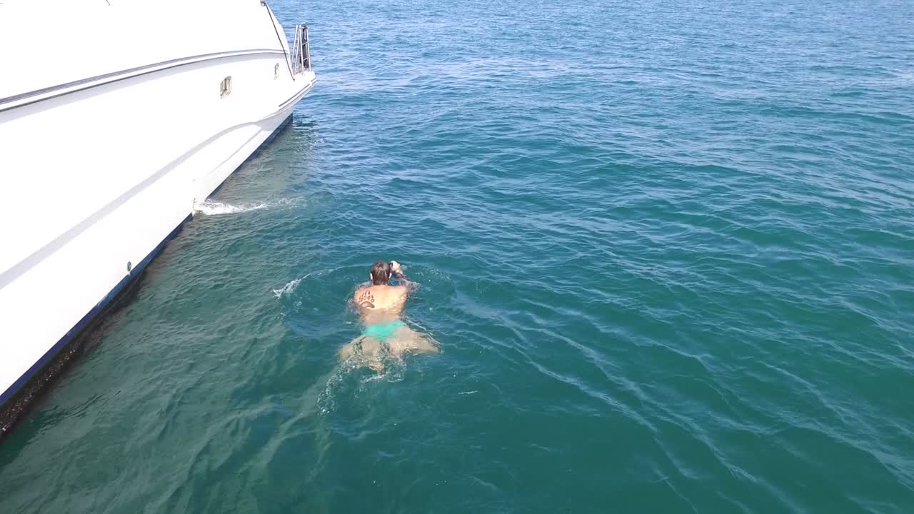 요트 근처 에서 수영 하는 사람