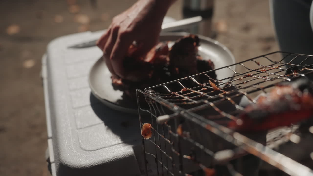 Cena informale accanto al fuoco scoppiettante. Pasto serale rustico all'aperto con pollo arrosto e atmosfera accogliente. Godersi un caldo pasto al fuoco da campo con pollo alla griglia e un ambiente naturale invitante.