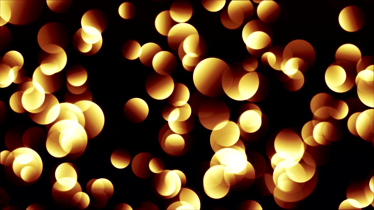 Particelle bokeh incandescenti giallo-rossastre su sfondo nero.