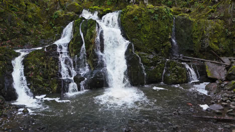 waterfall flowing through moss rocks in the pacific northwest