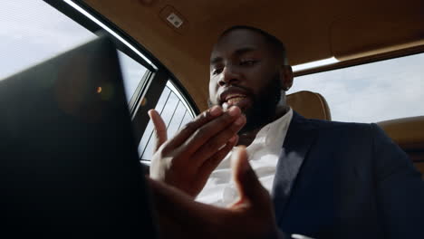 stressed african american man arguing on video call at car