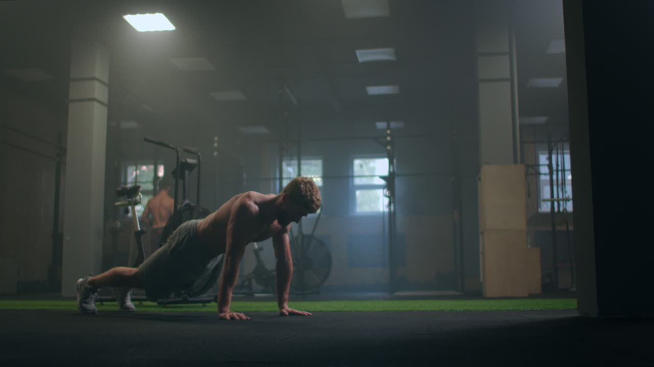 a strong purposeful man performs push-UPS despite fatigue and pain overcoming difficulties. the concept of a healthy lifestyle