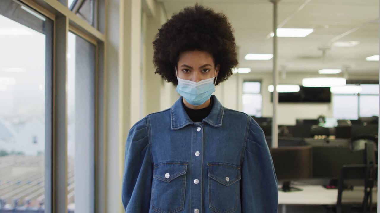 retrato de una mujer de negocios creativa afroamericana con máscara facial mirando a la cámara