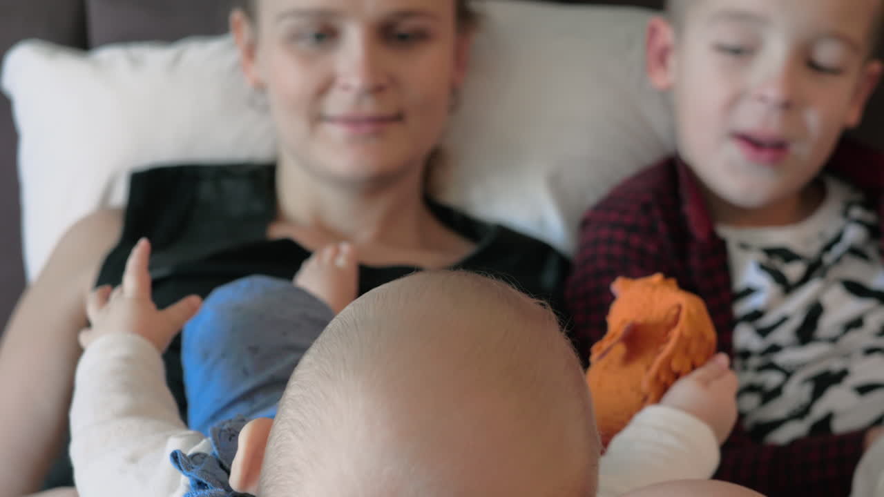 Madre con figlio maggiore e figlia neonata a casa