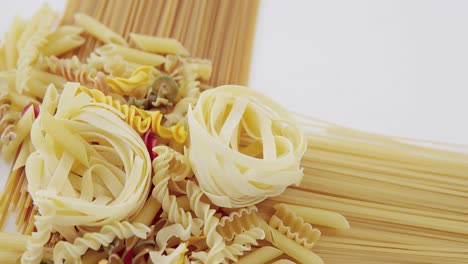 Various-colored-pasta-against-spaghetti-background