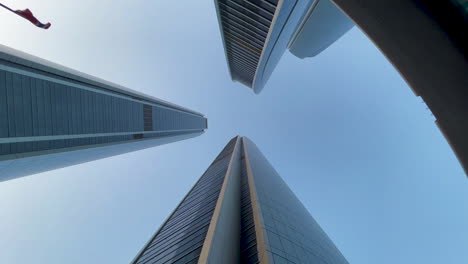 warms eye view of skyscrapers with the camera rotating around them underneath om slow motion