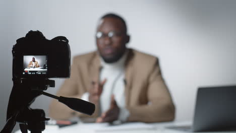 digital camera filming afro-american male vlogger