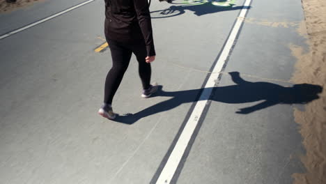 Mujer-De-Negro-Dando-Un-Paseo-Por-El-Carril-Bici-De-La-Playa-De-Santa-Monica-Beach