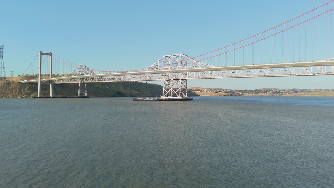 Panning drone perspective highlights the scale and symmetry of the Alfred Zampa Bridge spanning the northern California waterway