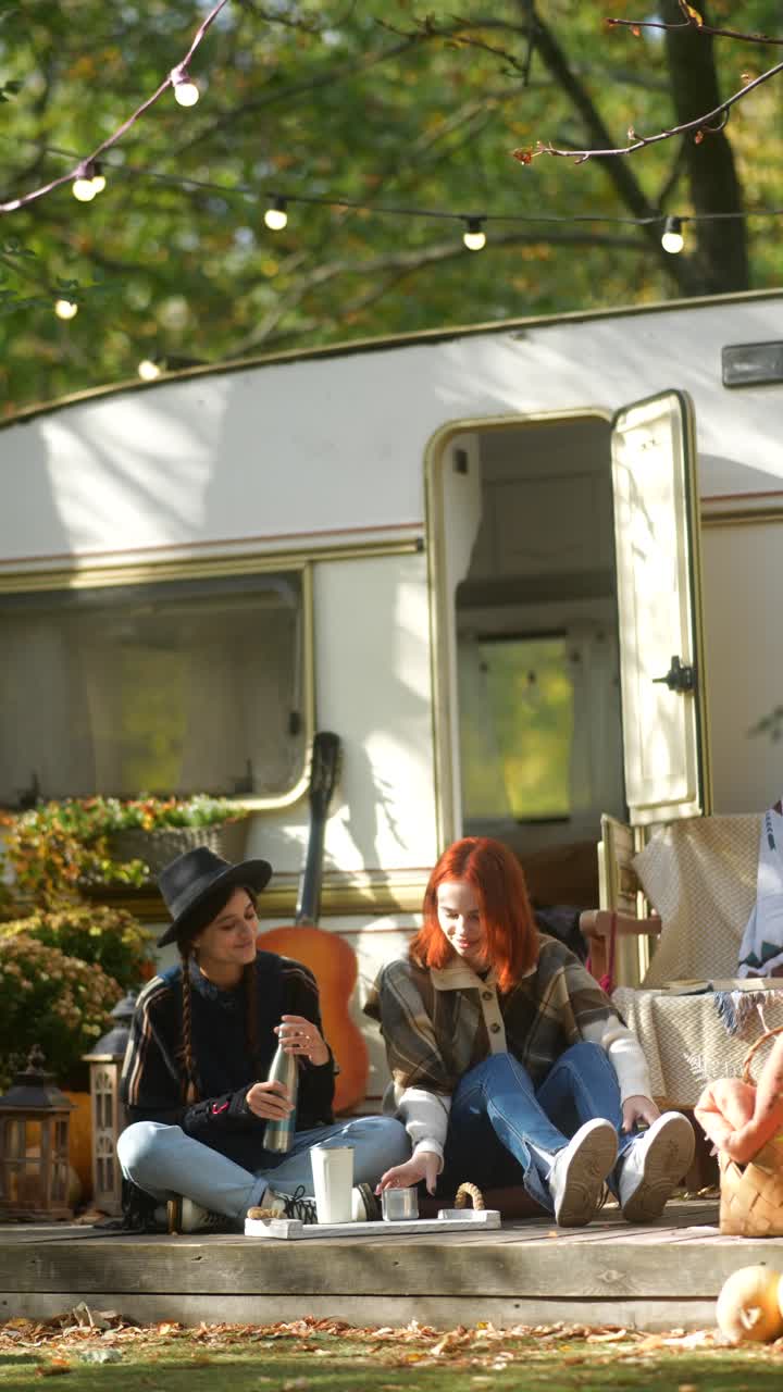 두 친구 가 가을 캠핑 여행 을 즐기고 있다