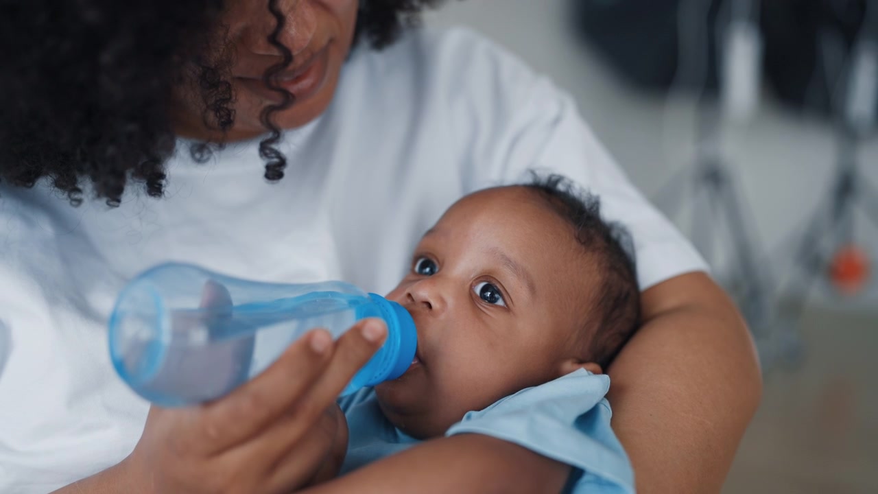 Madre che nutre il suo neonato con il biberon