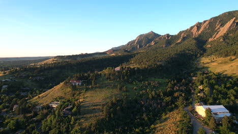 Drone-flying-over-houses-in-the-city-of-Boulder,-Colorado,-USA-at-sunrise-on-a-summer-morning
