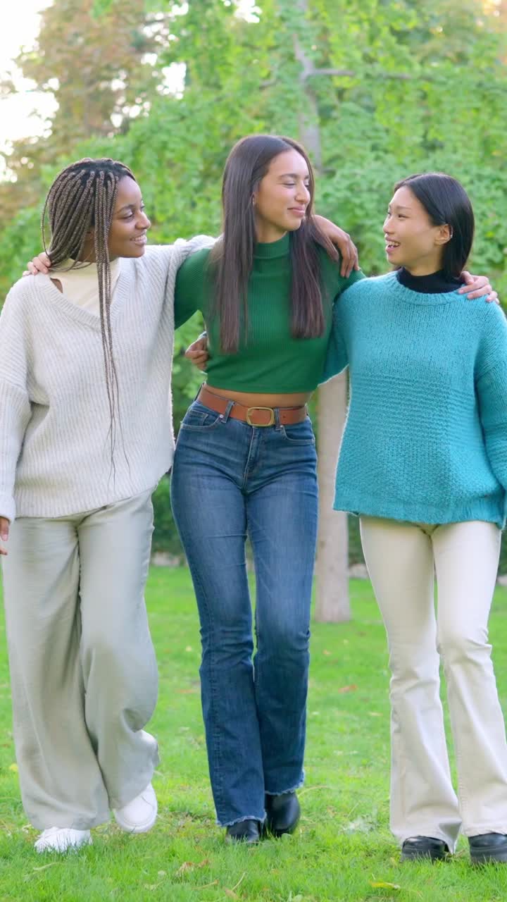 Three diverse friends walking and talking in a park