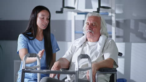 nurse assisting elderly patient in rehabilitation facility