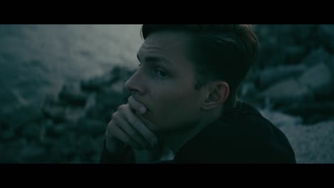 man contemplating by the water