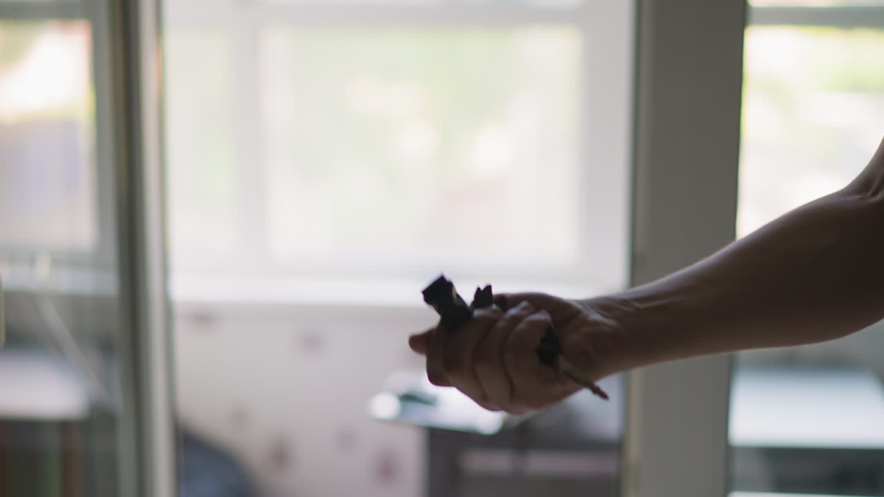 Person tosses and catches car key with fob in light room