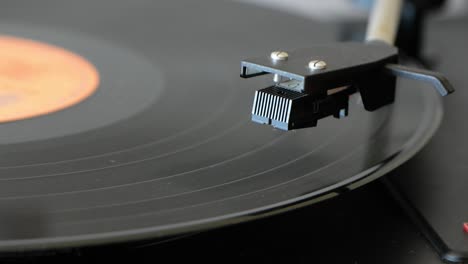 Vinyl-record-player-spinning-on-vintage-vinyl-turntable-player-and-being-stopped