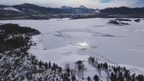 Downtown-Frisco-toward-Keystone-Colorado-aerial-cinematic-drone-Lake-Dillon-Marina-Summit-cove-cloudy-snowy-winter-morning-view-Silverthorne-Ten-Mile-Range-Breckenridge-calm-unfrozen-ice-forward