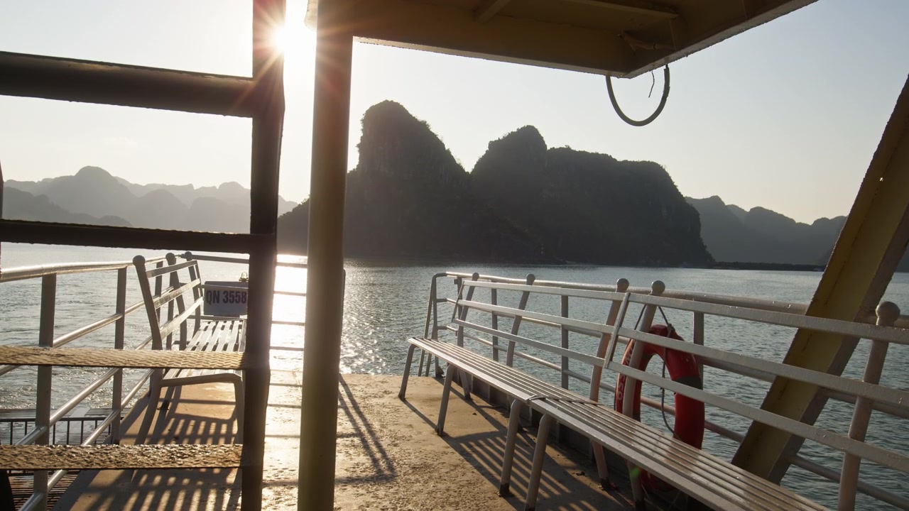 Metallbänke auf dem Deck einer Fähre für Passagiere mit Kalkstein-Karstinseln in Vietnam. Weitwinkelaufnahme.