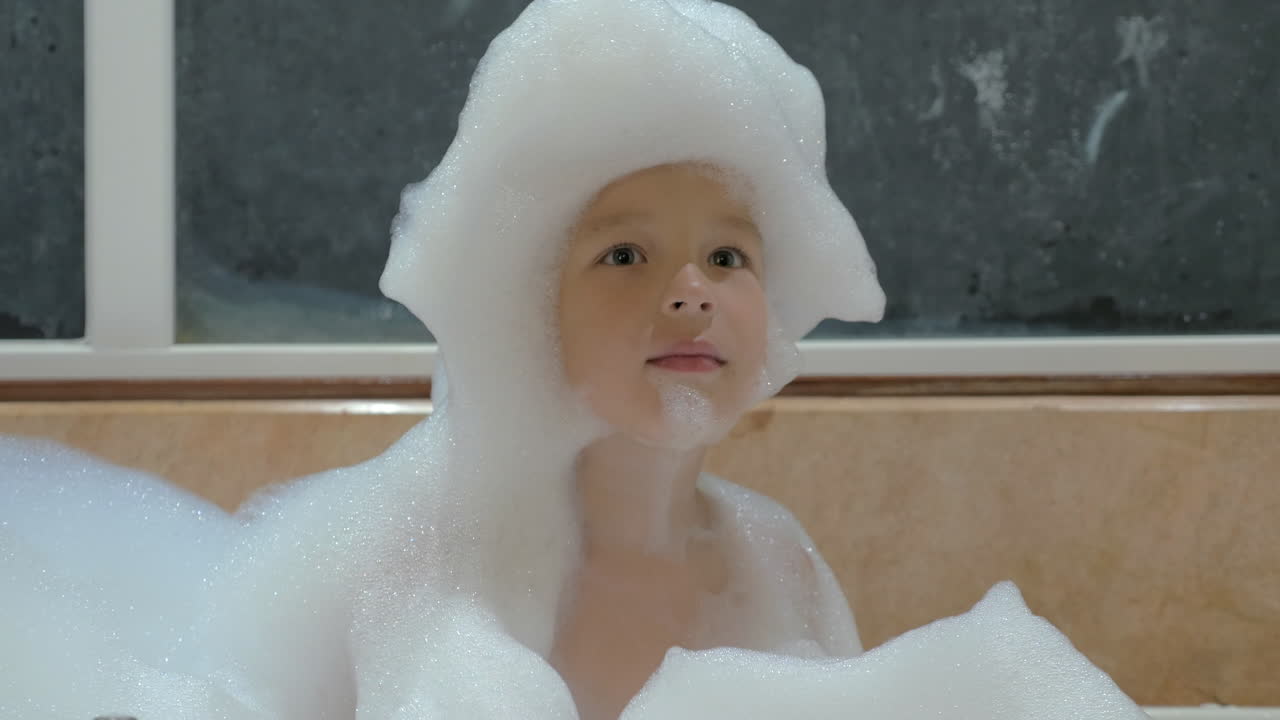 목욕탕 에서 거품 을 사용 하여 재미 를 느끼는 아이
