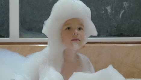 child having fun with foam in the bath