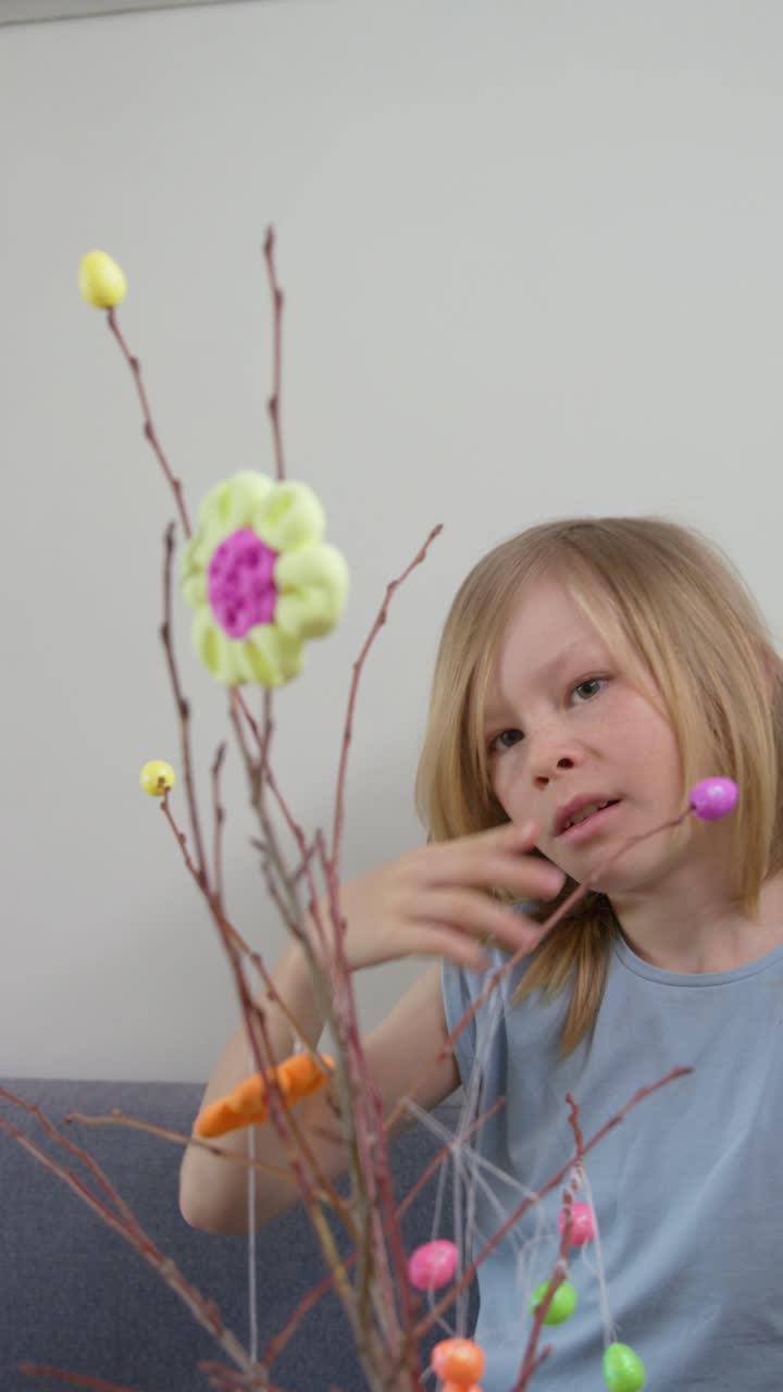 Young Girl Decorating Easter Branches with Colorful Ornaments