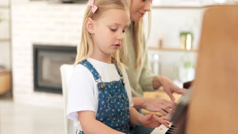 girl learning piano with mother