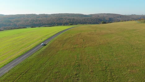 Weißes-Auto,-Das-Während-Der-Herbstfarben-Durch-Die-Malerische-Landschaft-Fährt