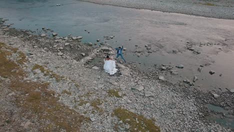 Wedding-couple-stand-near-mountain-river.-Groom-and-bride.-Arial-view