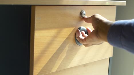 Mans-hand-open-drawer-wooden-in-cabinet