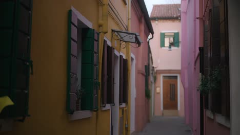 calle estrecha con casas coloridas de la isla de burano, italia