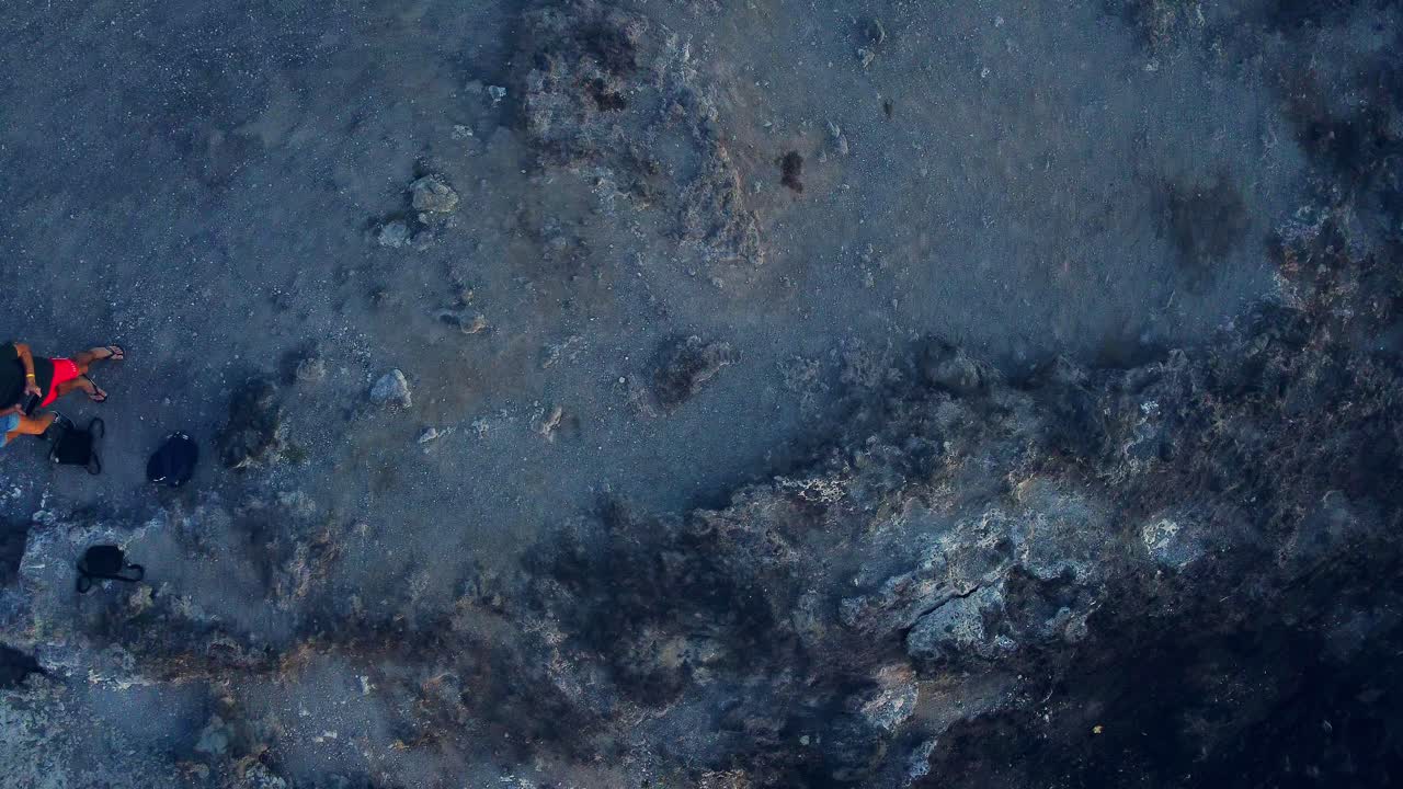 par de pie sobre una colina rocosa en la popular playa de los cristianos, tenerife, españa