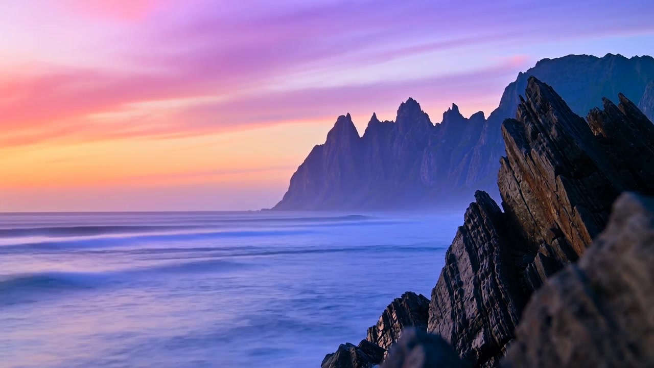 Coucher de soleil projetant une ombre profonde sur une falaise rocheuse à droite de la côte, mer brumeuse, crête déchiquetée à gauche, espace pour le texte.