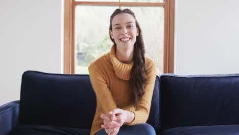 happy caucasian woman sitting on sofa and having video call in sunny living room,copy space
