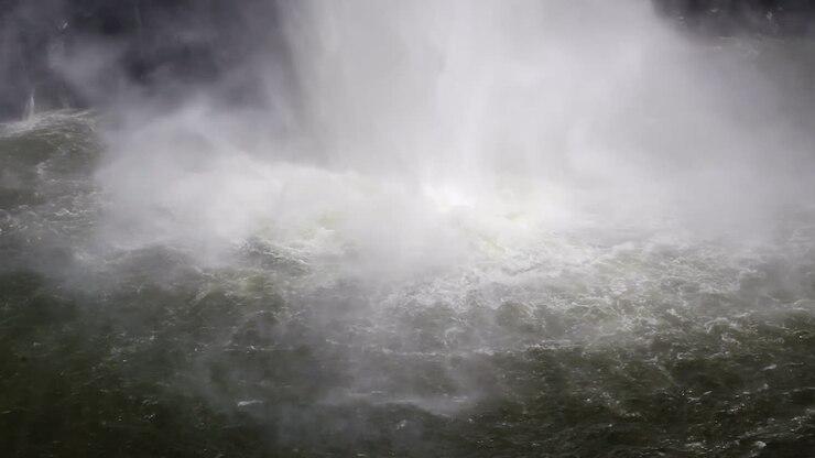 Base of powerful waterfall throws up mist from plunge pool water