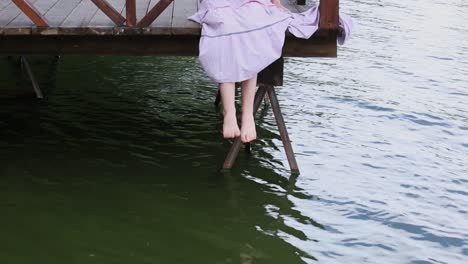 woman sitting on a wooden pier by the water