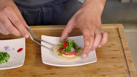 a chef picks up an appetizer and moves it off of a plate