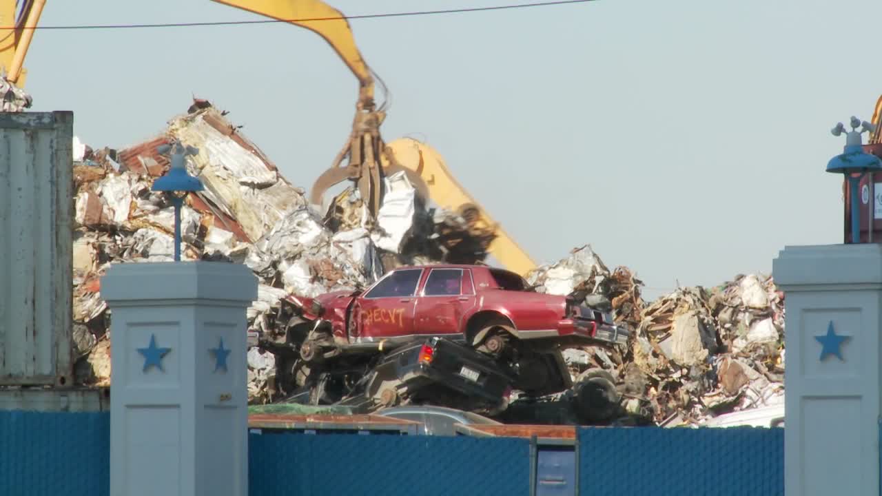 las grúas levantan y mueven chatarra alrededor de automóviles abandonados y destruidos en un depósito de chatarra o depósito de chatarra 1