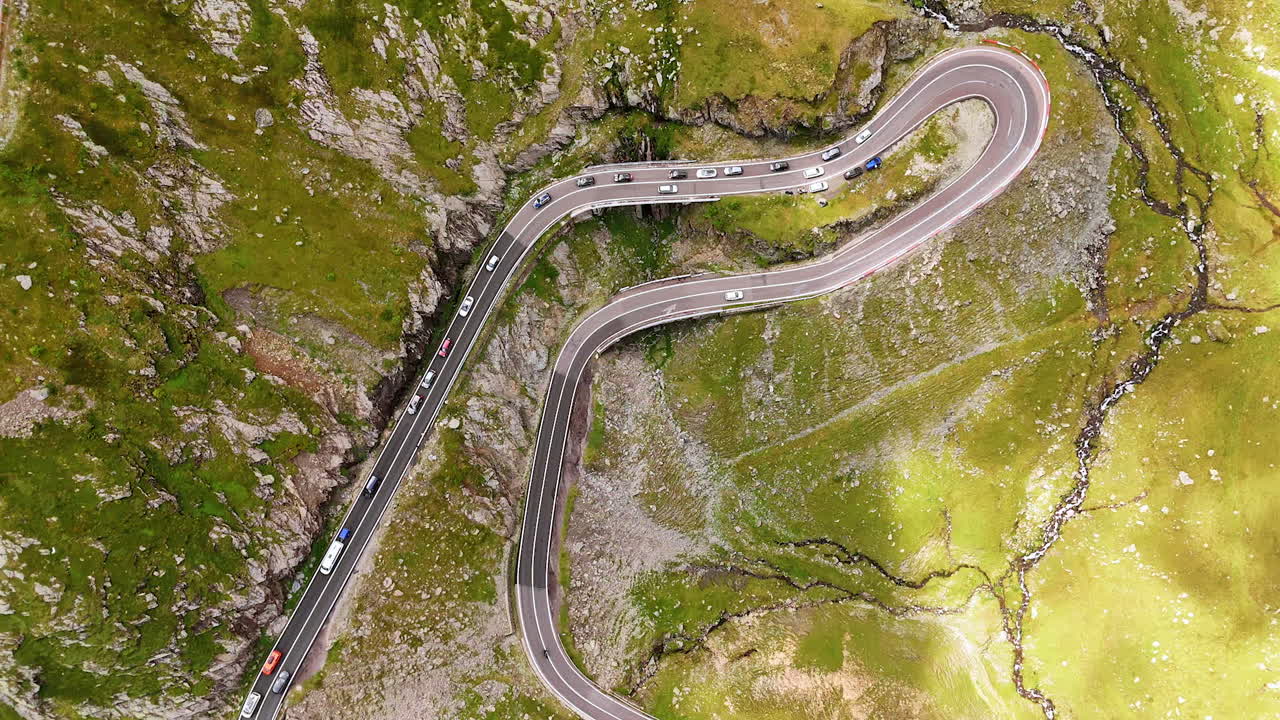 Lots of cars gathered on the part of the famous Transfagarash road. Drone flight above the Carpathian Mountains, Romania