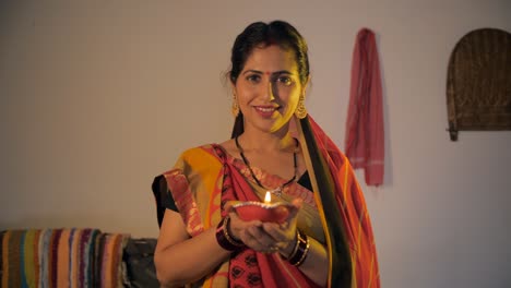 portrait of a beautiful indian village woman holding a diya during diwali festival