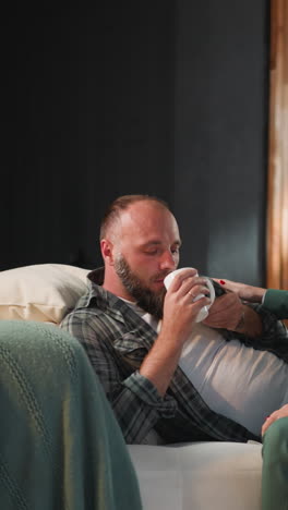 caring wife gives pill to husband kissing and walking away. woman takes care of bearded man with cardiac disease giving medicaments for quick recovery