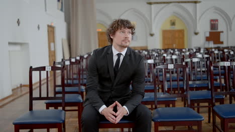 man in suit waiting in a church