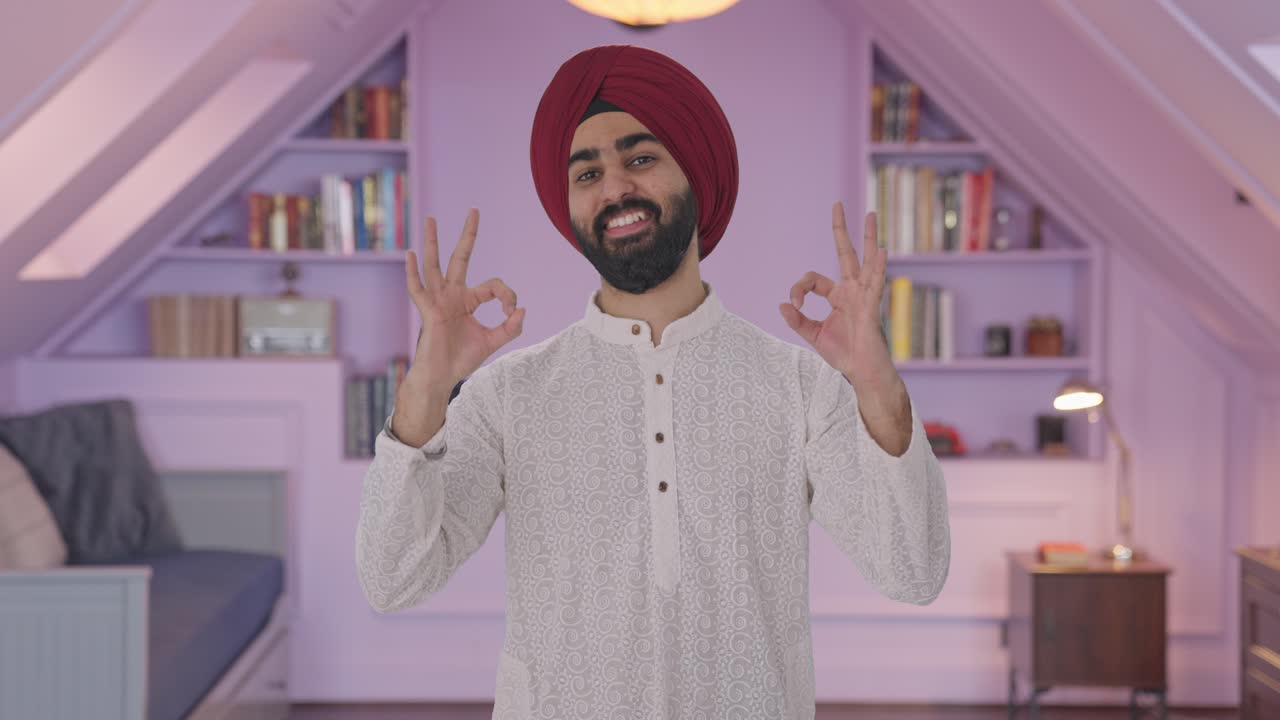 Uomo indiano Sikh felice che fa il segno dell'ok