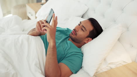 Morning,-phone-and-man-texting-in-bed-relaxing