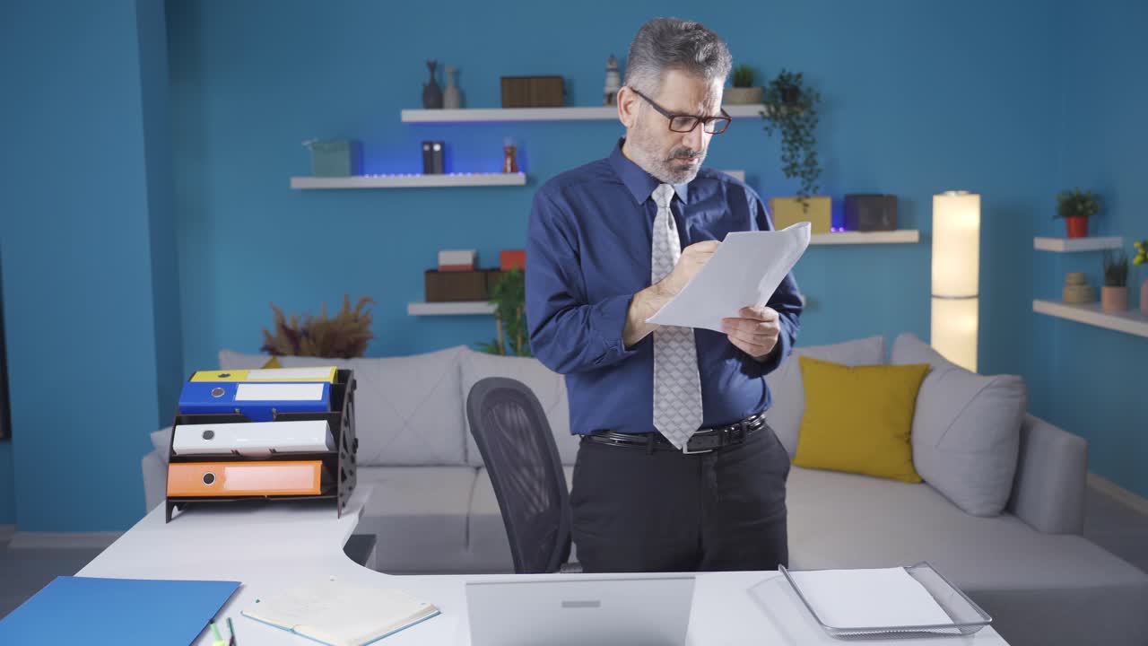 L'uomo d'affari, che gestisce la sua attività da casa, pensa a cosa può fare per la sua attività e prende appunti su carta.