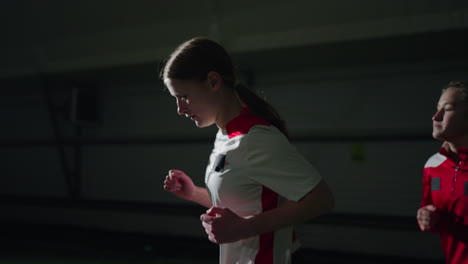 joven equipo de fútbol femenino corriendo durante el entrenamiento en interiores