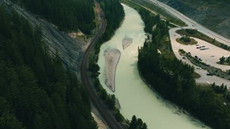 Columbia-Shuswap,-Fly-Over-River,-Railway-,Highway-and-Forest-Trees,-Hazy-Wildfire-Smoke,-Wide-Establishing-Aerial,-British-Columbia,Canada